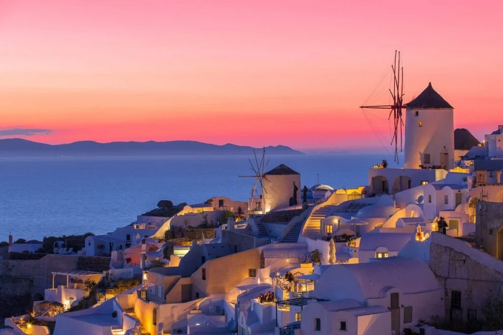 Santorini sunset with illuminated white buildings